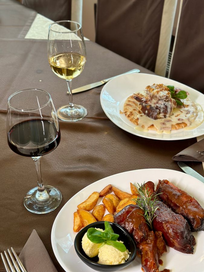 Rebra sa pečenim krompirom uz čašu vina