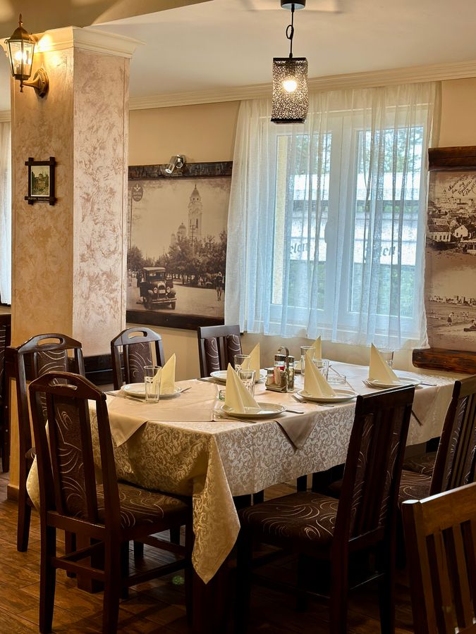 Sala restorana sa drvenim detaljima i belim zavesama